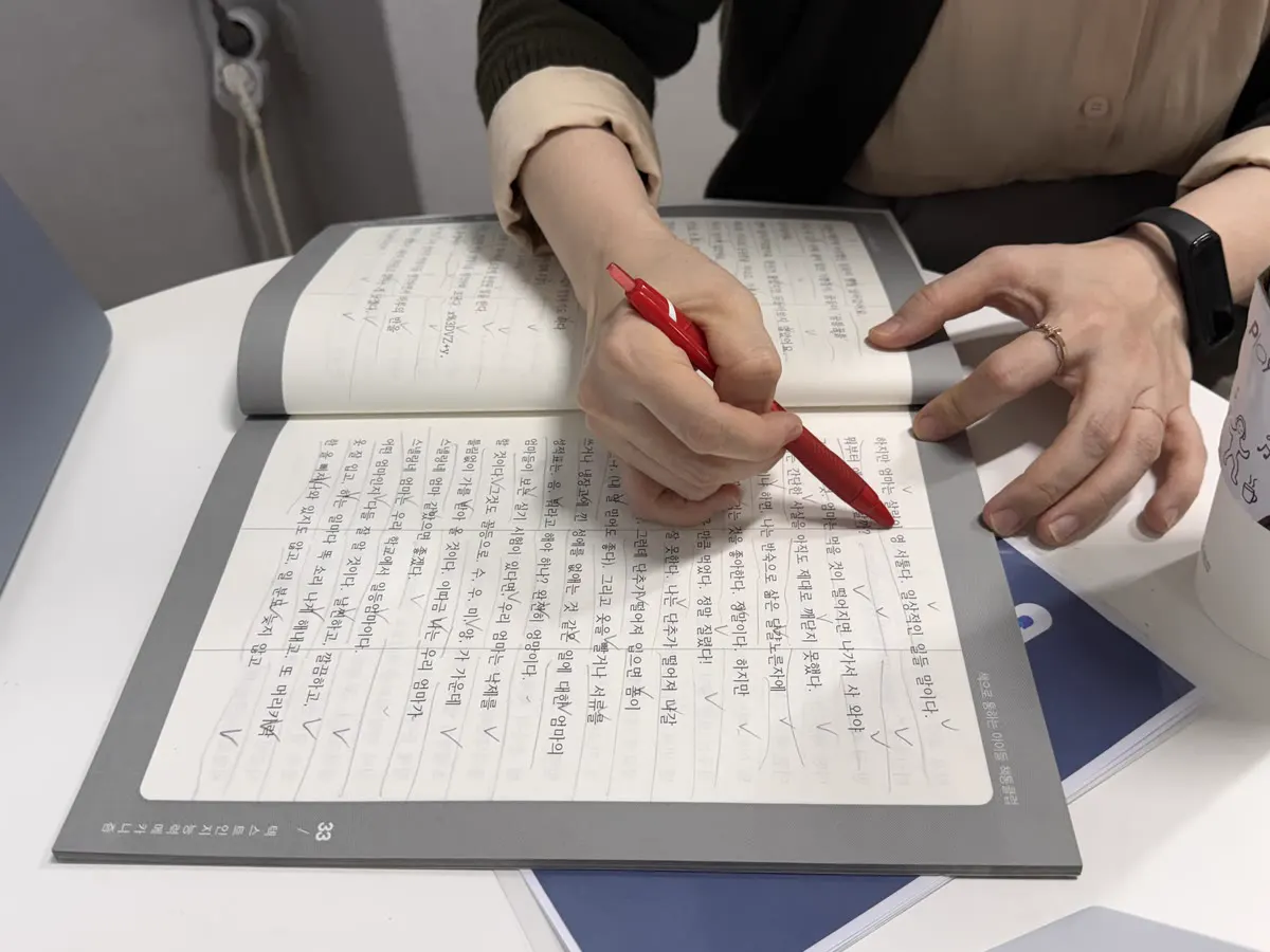 읽은 내용을 자기 말로 적은 독서 노트를 원장님이 살펴보는 모습