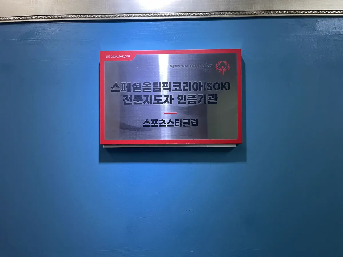 파란 벽에 걸린 전문 지도자 인증 기관 현판