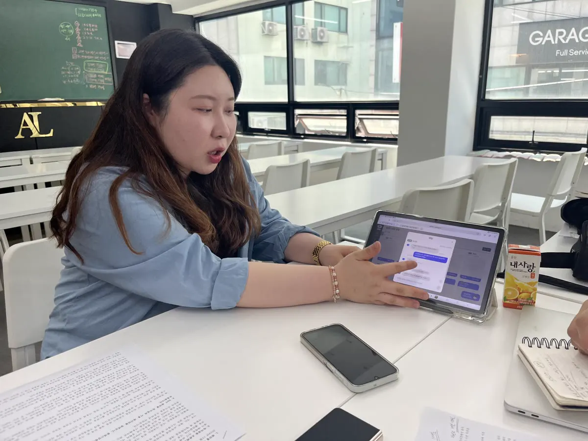 태블릿으로 채팅 상담 화면을 보여 주며 설명하는 모습